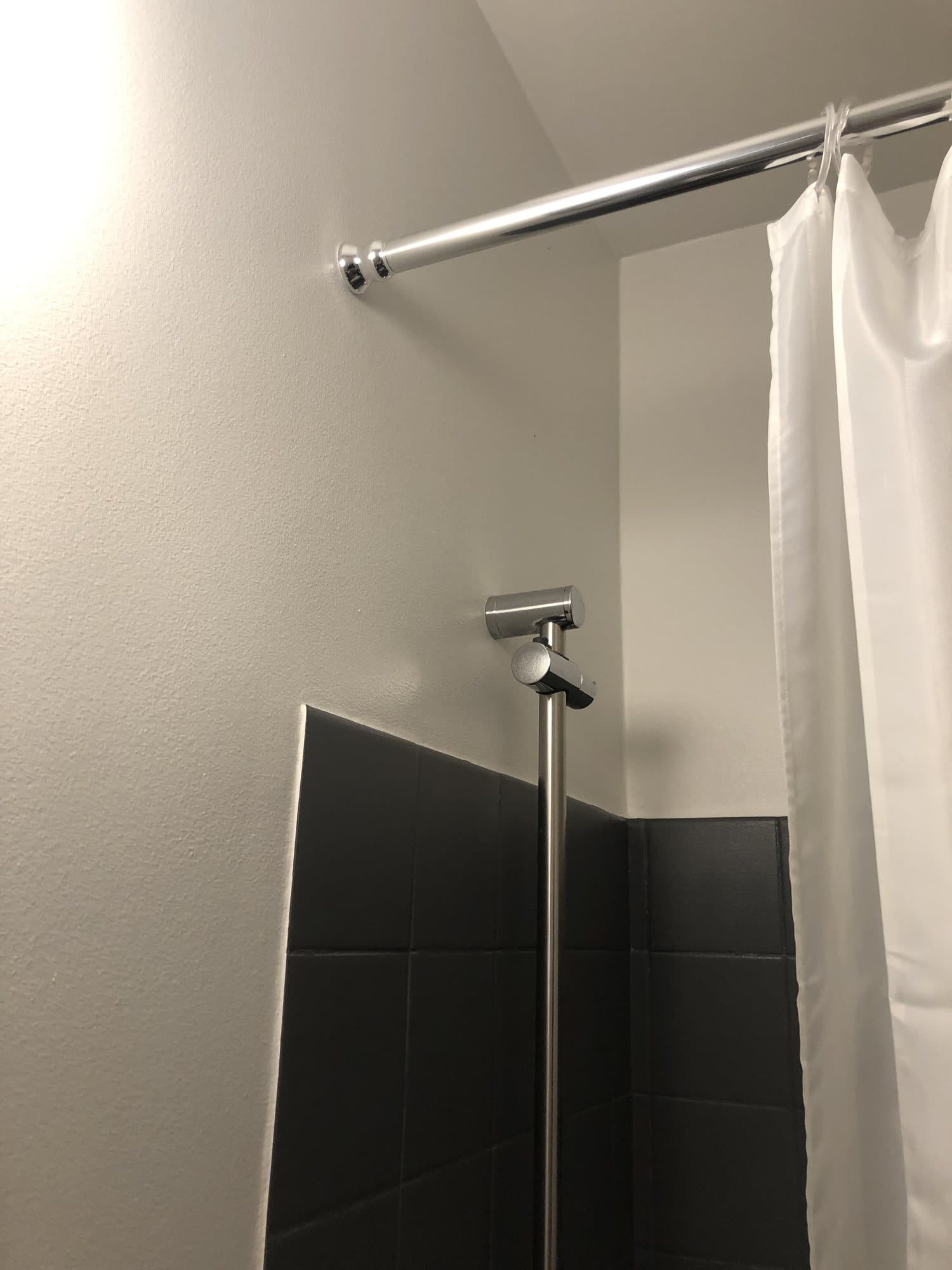 Badeværelse med nymalede vægge over sorte fliser